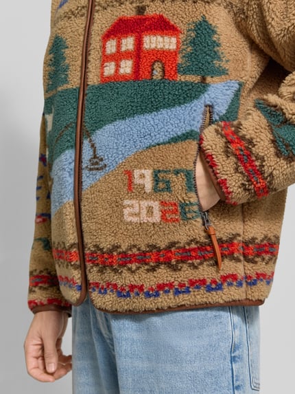 Männermodel trägt Regular Fit Sweatjacke mit Motiv-Print von Polo Ralph Lauren in Beige mit bunten Details, Nahaufnahme Oberkörper.