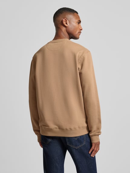 Männermodel trägt Sweatshirt mit Label-Detail von Scotch & Soda, Reine Baumwolle, Lockere Schnitt, Gerippte Abschlüsse, Rückenansicht.