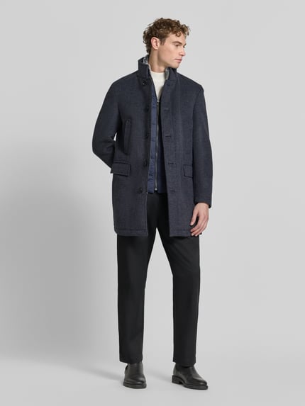 Mannelijk model draagt Regular Fit Mantel met Stehkragen van Christian Berg Men in donkergrijs, rechte lijnen, textuurmix, ganzlichaamsaanzicht van voren. Lanawol-mix, knoopsluiting, klepzakken, ruglengte 89 cm, schouderbreedte 49 cm, borstwijdte 50 cm, mouwlengte 66 cm.
