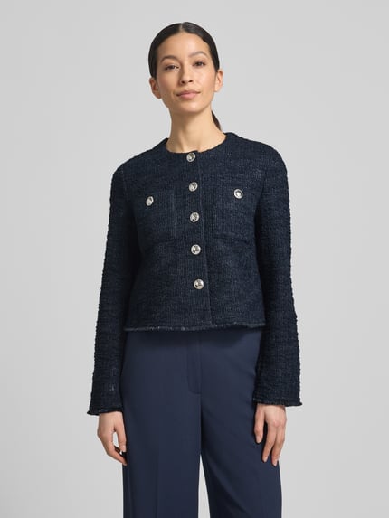 Frauenmodel trägt Slim Fit Blazer in Bouclé-Optik von Betty Barclay, dunkelblauer Baumwoll-Mix mit silbernen Knöpfen, Ganzkörperansicht von vorne.