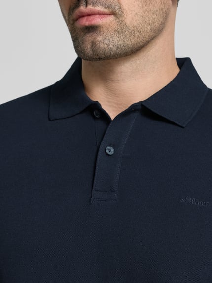 Mężczyzna nosi Regular Fit Poloshirt aus reiner Baumwolle von s.Oliver RED LABEL, ciemnogranatowa, gładka faktura, zbliżenie na górną część tułowia