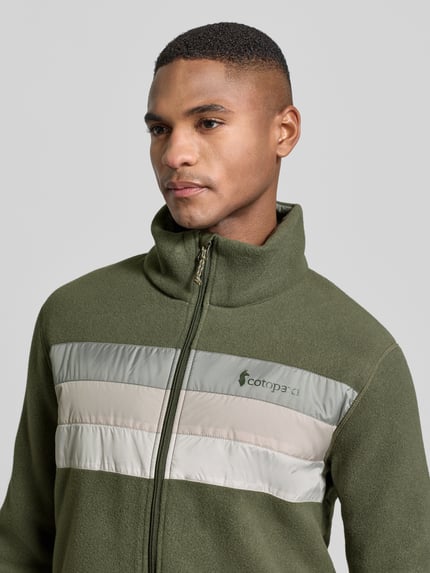Männermodel draagt Cotopaxi Jacke mit Stehkragen Modell 'Teca', regular fit, labelprint, ritssluiting, steekzakken, olijfgroen, Nahaufnahme Oberkörper.