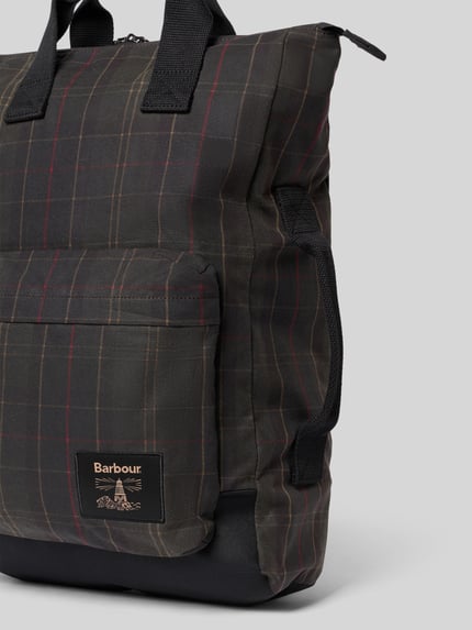 Produktfoto, Rucksack aus reiner gewachster Baumwolle von Barbour mit kariertem Muster in dunklen Farbtönen und sichtbarem Label. Herren Rucksack von Barbour
