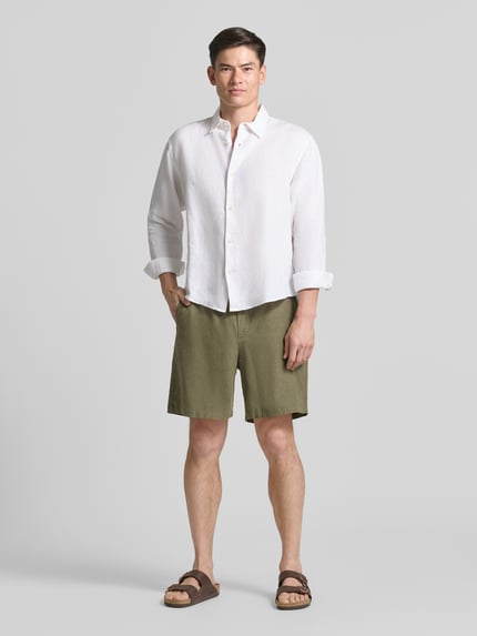 Männermodel trägt Leinenshorts mit elastischem Bund von GAP in Olivgrün, Loose-Fit, Baumwolle-Leinen-Mix, Ganzkörperansicht von vorne.