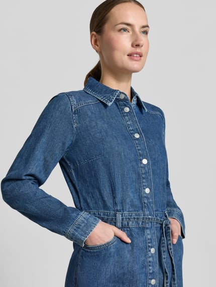 Modelka kobieca nosi Jeanskleid mit Taillengürtel od Tom Tailor Denim, bawełna, denim, krój regular fit, 5-kieszeni, niebieski; zbliżenie na górę ciała.