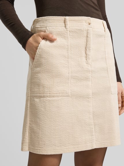 Vrouwenmodel draagt Minirok met steekzakken model 'Reah' van OPUS, beige katoen met cordstructuur, losse pasvorm, detailopname heup.