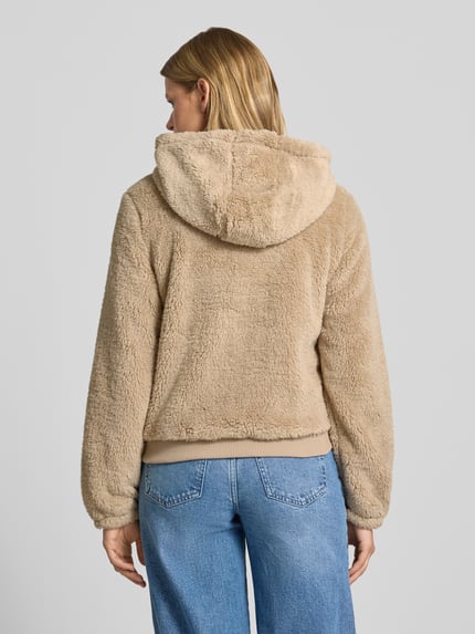 Frauenmodel trägt Regular Fit Teddyjacke mit Kapuze Modell 'NEWANNA' von ONLY, beigefarbene Textur, lockere Passform, Ganzkörperansicht Rückansicht, Damen Sweatjacke von ONLY.