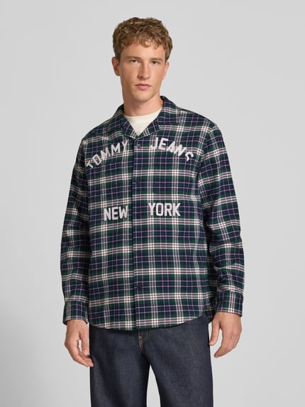 Männermodel trägt Relaxed Fit Freizeithemd aus reiner Baumwolle von Tommy Jeans in dunkelgrün kariert, Ganzkörperansicht von vorne, Herren Freizeithemd von Tommy Jeans.