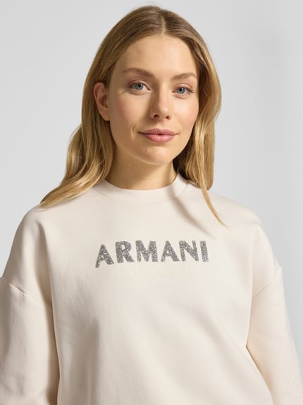 Frauenmodel trägt Sweatshirt mit Logo-Print und Rundhalsausschnitt von ARMANI EXCHANGE aus Baumwoll-Mix mit Stretch-Anteil, Loose-Fit, Nahaufnahme Oberkörper.
