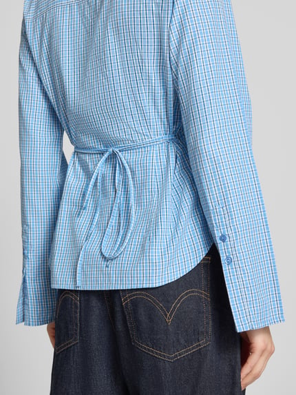 Vrouwenmodel draagt Regular Fit blouse met strikceintuur model 'CARO' van JJXX, materiaalmix met katoen, ruglengte maat S 64 cm, mouwlengte 64 cm, ruitjesmotief, detailopname rugaanzicht.