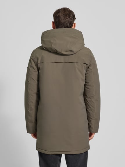 Männermodel draagt Parka met klepzakken model 'AIDEN' van Didriksons in olijfgroen, regular fit, ruglengte 92 cm, Ganzkörperansicht Rückansicht.