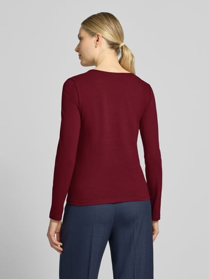Vrouwenmodel draagt Longsleeve met Rundhalsausschnitt van ZABAIONE in bordeaux, mix van katoen en elastaan, getailleerd model, ruglengte bij maat S 55 cm, geheellichaamsaanzicht van achteren.