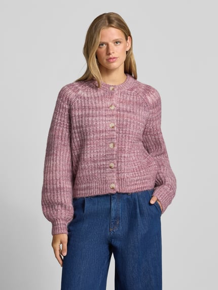 Frauenmodel trägt Cardigan mit Woll-Anteil und Rundhalsausschnitt von REVIEW, Material-Mix, gerade geschnitten, Strukturstrick in Rosa, Ganzkörperansicht von vorne.