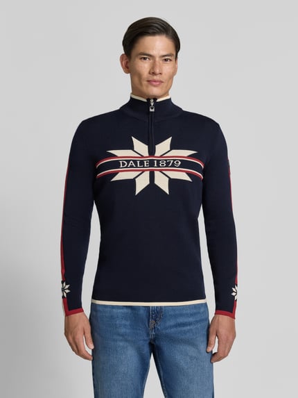 Männermodel trägt Wollpullover mit Label-Print Modell 'Nale' von Dale of Norway in Dunkelblau, Reine Wolle, Ganzkörperansicht von vorne.