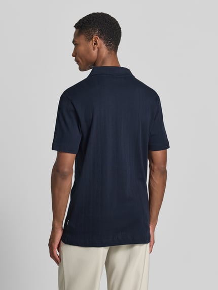 Männermodel trägt Regular Fit Poloshirt in Jaquard-Strick von Lindbergh in Dunkelblau aus Reine Baumwolle, Rückenlänge 73 cm, Ganzkörperansicht Rückansicht.