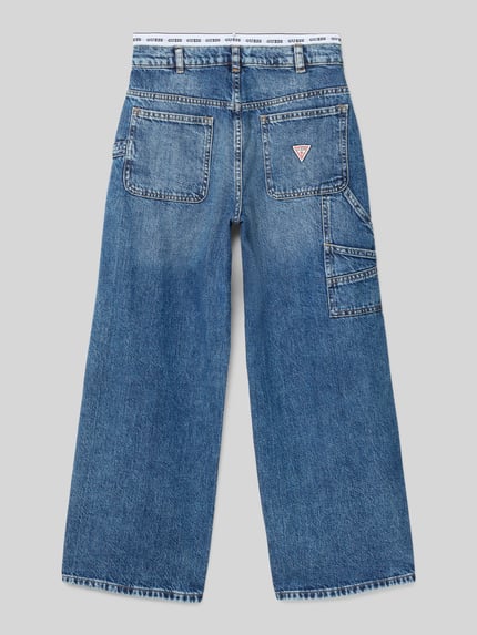 Produktfoto, gerade geschnittene Kinderjeans Straight Fit Jeans mit Logo-Stitching von Guess aus reiner Baumwolle, sichtbare Logo-Applikation, blaue Farbe, sichtbare Eingriff- und Gesäßtaschen, strukturierte Oberfläche, weite Hosenbeine, Knopf- und Reißverschluss, Bundweite 35 cm und Innenbeinlänge 64 cm bei Größe 140.