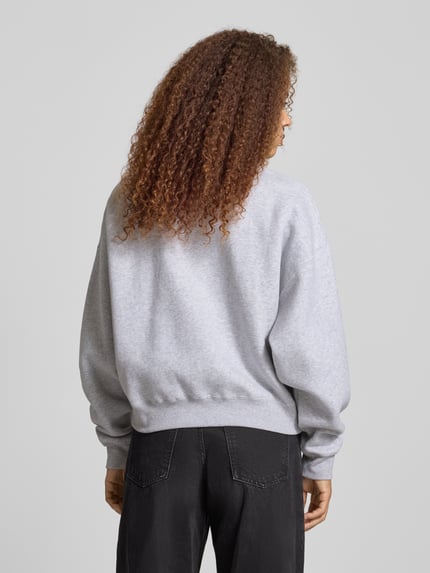 Frauenmodel trägt Sweatshirt mit Motiv-Print Modell 'Nina' von OH APRIL aus Baumwoll-Mix, Relaxed-Fit, Rückansicht Ganzkörperansicht.