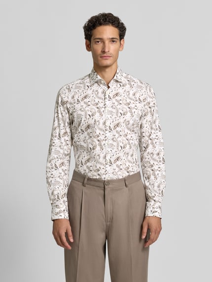 Männermodel trägt Body Fit Businesshemd aus Baumwoll-Mix von OLYMP Level 5 mit beigem Paisley-Muster, Ganzkörperansicht von vorne.
