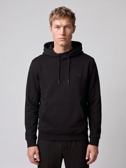 Männermodel trägt schwarzen Hoodie mit Logo-Patch Modell 'Wetalk' von BOSS Orange, unifarben, strukturierte Jersey-Optik, Ganzkörperansicht von vorne