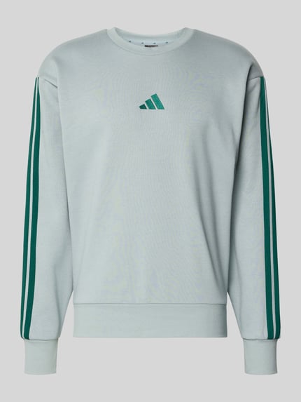 Produktfoto, Sweatshirt mit Rundhalsausschnitt und Logo von adidas Sportswear, bawełniany mix z dodatkiem wiskozy, krój regular fit, zielone paski na rękawach, logo z przodu, kolor jasnoszary, długość pleców w rozmiarze M: 70 cm, długość rękawa w rozmiarze M: 64 cm