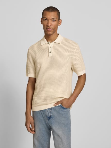 Männermodel trägt Regular Fit Poloshirt in Strick-Optik Modell 'Kingsley' von Jack & Jones Premium, beige, Kurzarm, Baumwolle, Ganzkörperansicht von vorne.