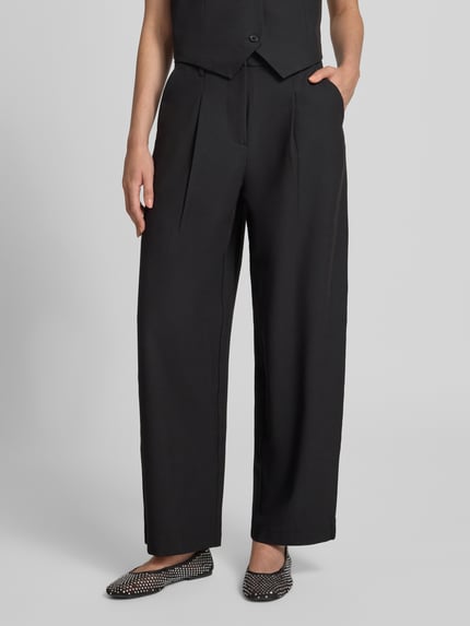 Frauenmodel trägt schwarze Slim Fit Anzughose mit Viskose-Anteil Modell 'BOSELLA' von PIECES, weite Form, glatte Textur, Nahaufnahme Oberkörper.