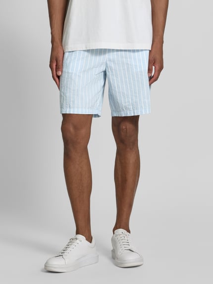 Männermodel trägt Regular Fit Shorts aus reiner Baumwolle Modell 'STUART' von SELECTED HOMME in hellblau gestreift, Nahaufnahme Oberschenkel.