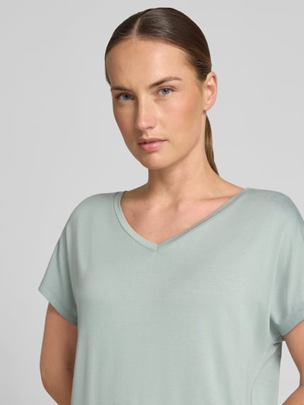 Frauenmodel trägt T-Shirt aus Viskose-Elasthan-Mix mit V-Ausschnitt von Christian Berg Woman, Damen T-Shirt, Relaxed-Fit, Kappärmel, Rückenlänge 63 cm bei Größe S, hellgrün, glatte Oberfläche, Nahaufnahme Oberkörper.