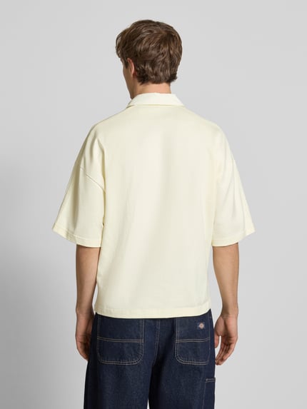 Männermodel trägt Regular Fit T-Shirt mit Polo-Kragen von adidas Originals in Creme, reine Baumwolle, Rückenansicht, Ganzkörperansicht Rückansicht.