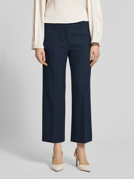 Frauenmodel trägt Wide Fit Stoffhose mit Viskose-Anteil Modell 'Olessa' von Raffaello Rossi in Dunkelblau mit Bügelfalten und Crêpe-Verarbeitung, Elastischer-Material-Mix, Haken-Reißverschluss, Ganzkörperansicht von vorne.