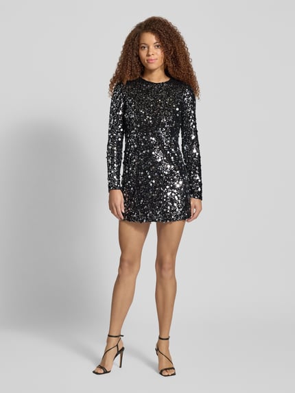 Frauenmodel trägt fließendes Abendkleid mit Paillettenbesatz Modell 'ANIKA CATINA' von Only, Mini-Länge, glänzendes Mesh, Ganzkörperansicht von vorne.