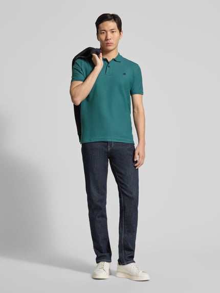 Männermodel trägt Poloshirt mit Logo-Stitching Modell 'PERFORMANCE' von Lerros in Türkis auf Jeans, Baumwoll-Mix, Regular Fit, Ganzkörperansicht von vorne.
