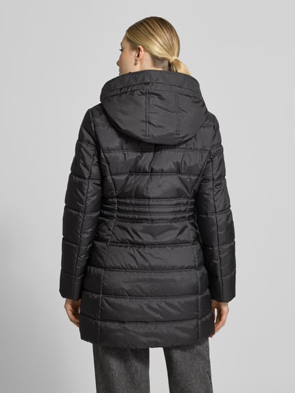 Frauenmodel trägt Steppmantel mit Kapuze Modell 'LT SEPTEMBER' von BETTY BARCLAY in Schwarz, strukturierte Longline-Webware, Ganzkörperansicht Rückansicht.