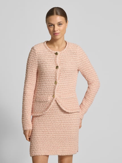 Vrouwenmodel draagt Slim Fit Blazer in tricotlook van Marc Cain in lichtroze katoenmix met ronde hals, knoopsluiting, glitterdetails, Ganzkörperansicht von vorne.