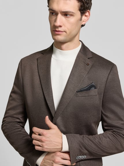 Männermodel trägt Regular Fit Sakko mit Brustleistentasche Modell 'DiNick' von Zuitable, feines Webstruktur-Muster, Nahaufnahme Oberkörper.