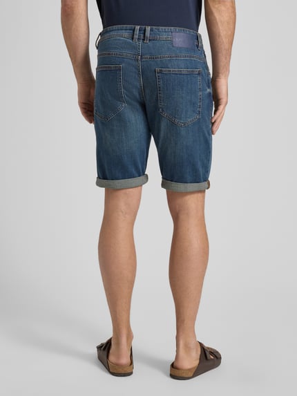 Männermodel trägt Regular Fit Jeans Bermudas aus Baumwoll-Mix von Tom Tailor in Denim-Optik mit Label-Patch, Ganzkörperansicht Rückansicht.