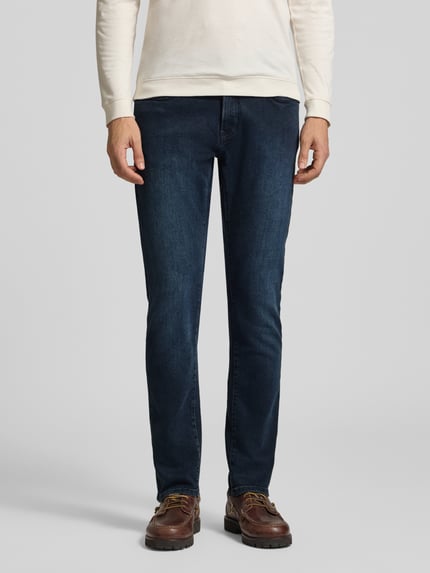 Männermodel trägt Straight Fit Jeans aus elastischem Baumwoll-Mix Modell 'Lyon' von Pierre Cardin in Dunkelblau, Ganzkörperansicht von vorne. Herren Jeans mit 5-Pocket-Design, Gürtelschlaufen, Knopf- und Reißverschluss, Bundweite 45 cm, Innenbeinlänge 83 cm.