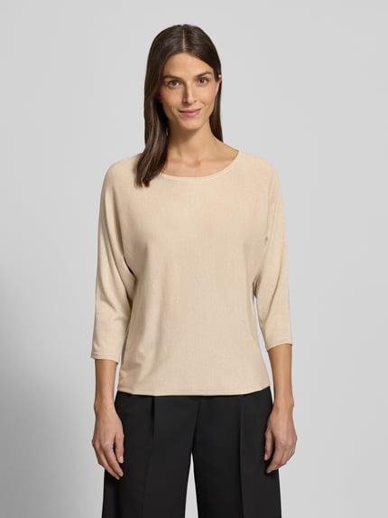 Frauenmodel trägt Relaxed Fit Pullover aus Viskose-Mix in Strick-Optik von Comma in Glitzer-Optik, U-Boot-Ausschnitt, 3/4-Arm, Ganzkörperansicht von vorne.