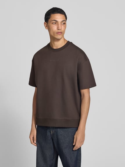 Männermodel trägt Boxy Fit Shirt aus Baumwoll-Mix von Marc O'Polo in Dunkelbraun, kombiniert mit Jeans, Ganzkörperansicht von vorne, Herren Oversized Shirt von Marc O'Polo DENIM.