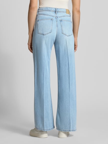 Vrouwenmodel draagt Wide Leg Jeans aus Lyocell-Baumwoll-Mix Modell 'SURI' van s.Oliver RED LABEL in denimlook, light blauwe kleur, 5-pocketmodel, mid waist, labelpatch, met riemlussen, tunnelkoord, knoop- en ritssluiting, gemaakt van mix van katoen en lyocell. Ganzkörperansicht Rückansicht.
