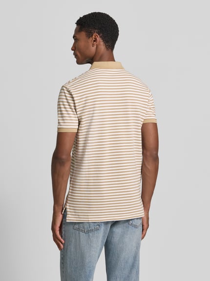 Männermodel trägt Slim Fit Poloshirt aus reiner Baumwolle Modell 'YD MESH STRIPE POLO' von Polo Ralph Lauren, beige-weiß gestreift, Ganzkörperansicht Rückansicht, Herren