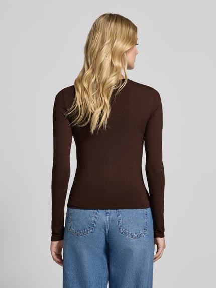 Frauenmodel trägt Slim Fit Basic Langarmshirt aus Baumwollmix von REVIEW in Braun zu blauer Jeans, Damen Longsleeve, Ganzkörperansicht Rückansicht.