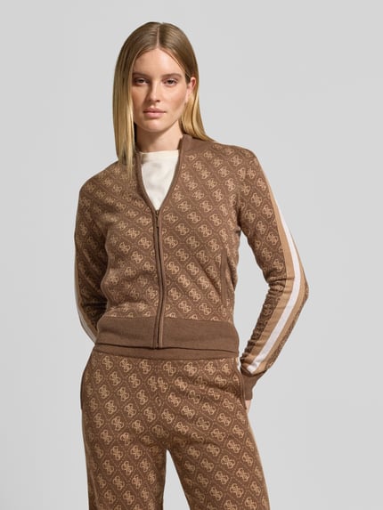 Vrouwenmodel draagt Strickjacke mit Logo-Muster Modell 'ANEIRA 4G' van GUESS Activewear, regular fit, allover look, bruine tinten, staande kraag, ritssluiting, detail logo-motief, Ganzkörperansicht van voren