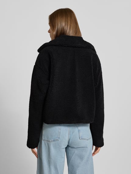 Vrouwenmodel draagt Cropped Jacke aus Teddyfell Modell 'Nati' van NOISY MAY®, zwart teddyfleece, cropped fit, volledige achteraanzicht.