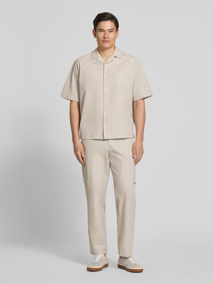 Männermodel trägt Relaxed Fit Cargohose mit Gürtelschlaufen Modell 'SRACKY' von BOSS Orange, unifarben, Ganzkörperansicht von vorne.