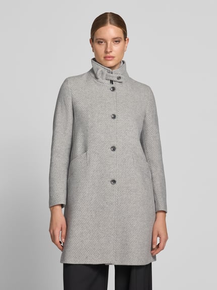 Frauenmodel trägt Mantel aus Woll-Mix mit Stehkragen Modell 'ASTOR' von CINQUE in Hellgrau, Knopfleiste, aufgesetzte Taschen, Gerader Schnitt, Ganzkörperansicht von vorne.