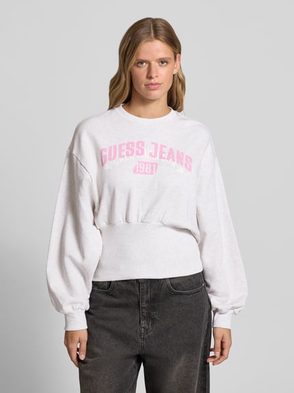 Vrouwenmodel draagt Sweatshirt met Label-Print en Rundhalsausschnitt van GUESS Jeans, wit, roze print, katoen, slim fit, Ganzkörperansicht van voren.