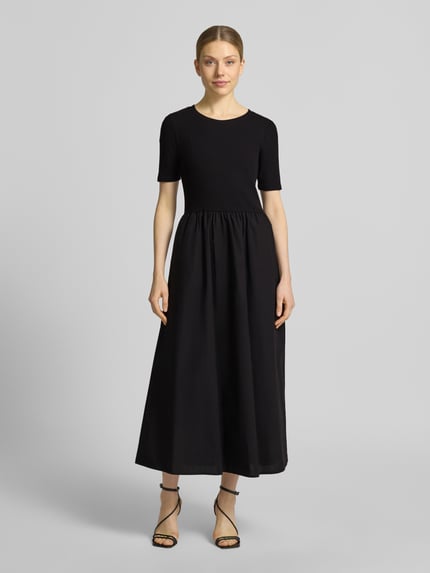 Frauenmodel trägt Midikleid in Falten-Optik von Christian Berg Woman Selection, Schwarz, Baumwoll-Mix, Taillierte Passform, Rundhalsausschnitt, Kurzärmelig, Ganzkörperansicht von vorne.