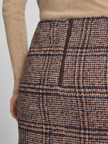 Frauenmodel trägt Minirock mit Woll-Anteil und rückseitigem Reißverschluss von Christian Berg Woman, braun-blau kariert, Material-Mix, Detailaufnahme.