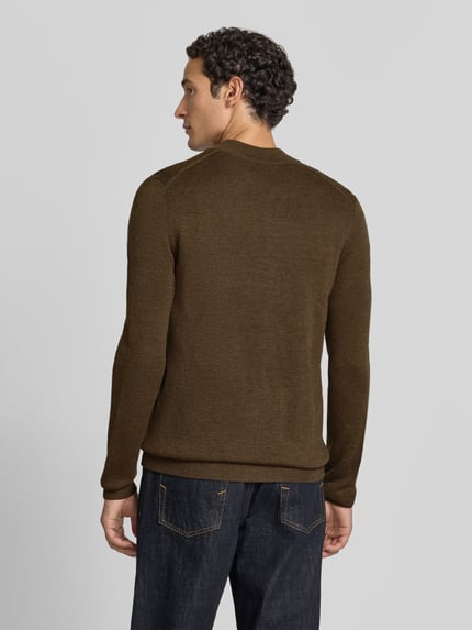 Männermodel trägt Slim Fit Strickjacke aus Baumwoll-Mix mit Stehkragen von Christian Berg Men in Braun, feine Strickstruktur, Jeans, Ganzkörperansicht Rückansicht.